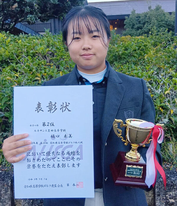 賞状とトロフィーを手に笑顔の樋口来美さん